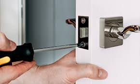 Door lock being repaired with a screwdriver